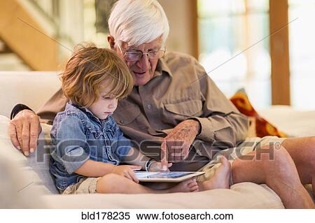 Caucasian grandfather and grandson using digital tablet View Large Photo Image Stock Photography - Caucasian grandfather and grandson using digital tablet. Fotosearch