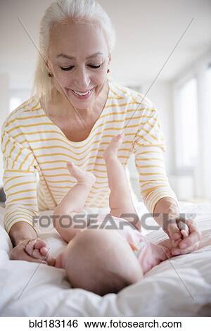 Stock Photograph - Caucasian grandmother admiring baby granddaughter. Fotosearch