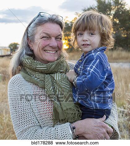 Stock Photo - Caucasian grandmother holding grandson outdoors. Fotosearch