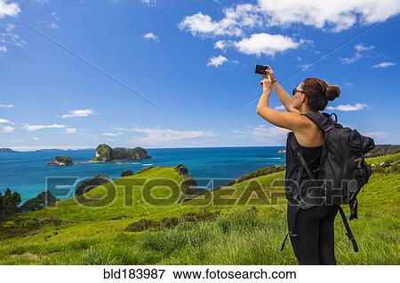 Caucasian hiker photographing cliff and seascape View Large Photo Image Stock Photo - Caucasian hiker photographing cliff and seascape. Fotosearch
