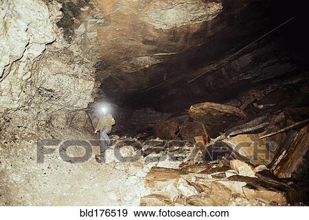 Caucasian hiker wearing headlamp in cave View Large Photo Image Stock Photo - Caucasian hiker wearing headlamp in cave. Fotosearch