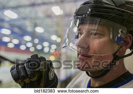 Stock Image - Caucasian hockey player wearing helmet. Fotosearch