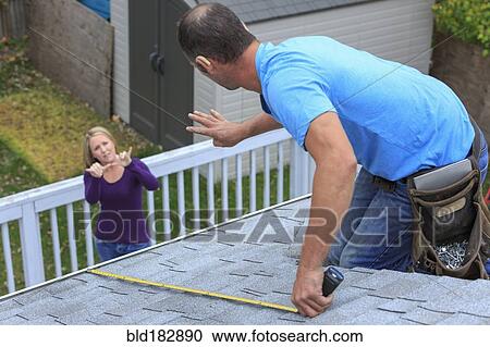 Stock Image - Caucasian homeowner signing to deaf roofer. Fotosearch