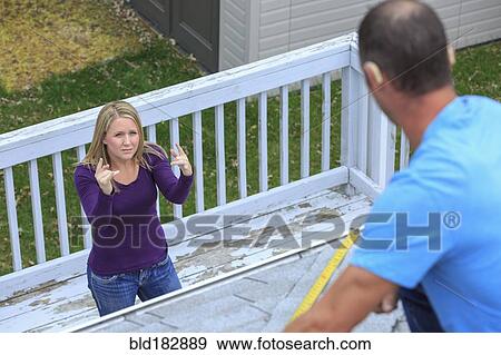 Caucasian homeowner signing to deaf roofer View Large Photo Image Stock Photo - Caucasian homeowner signing to deaf roofer. Fotosearch