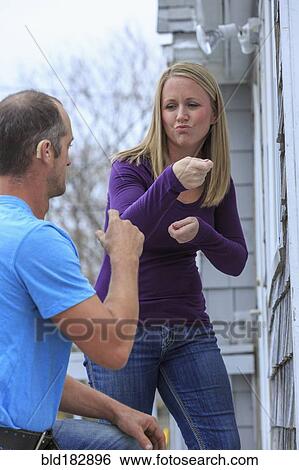 Stock Photograph - Caucasian homeowner signing to deaf repairman. Fotosearch