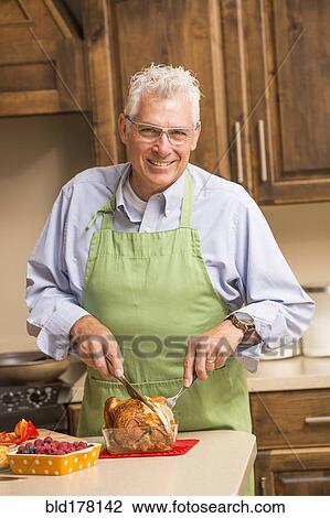 Caucasian man carving chicken in kitchen View Large Photo Image Stock Image - Caucasian man carving chicken in kitchen. Fotosearch