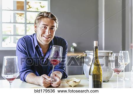 Stock Photograph - Caucasian man drinking wine in restaurant. Fotosearch