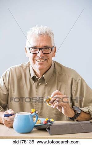Caucasian man eating at table View Large Photo Image Stock Photograph - Caucasian man eating at table. Fotosearch