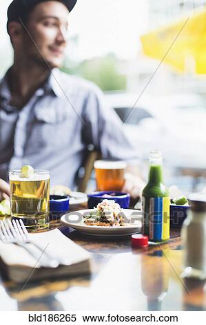 Stock Photography - Caucasian man eating tacos in restaurant. Fotosearch