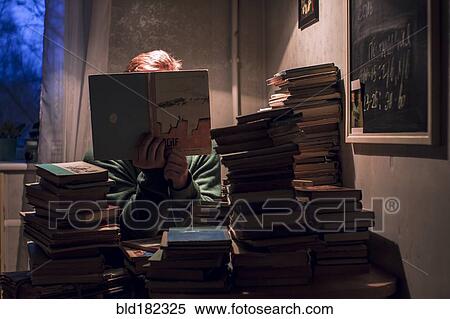 Stock Photography - Caucasian man reading stack of books. Fotosearch