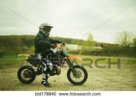 Caucasian man riding dirt bike in field View Large Photo Image Stock Image - Caucasian man riding dirt bike in field. Fotosearch