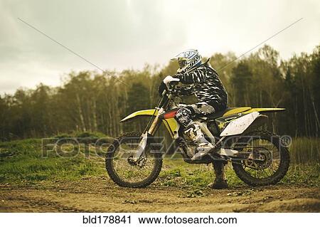 Caucasian man riding dirt bike in field View Large Photo Image Stock Image - Caucasian man riding dirt bike in field. Fotosearch