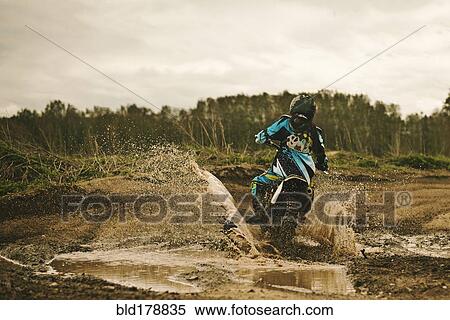 Caucasian man riding dirt bike in puddle View Large Photo Image Stock Photography - Caucasian man riding dirt bike in puddle. Fotosearch