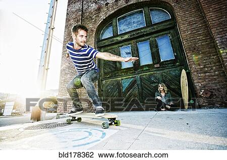 Caucasian man riding skateboard on sidewalk View Large Photo Image Stock Image - Caucasian man riding skateboard on sidewalk. Fotosearch