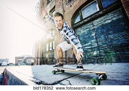Caucasian man riding skateboard View Large Photo Image Stock Image - Caucasian man riding skateboard. Fotosearch