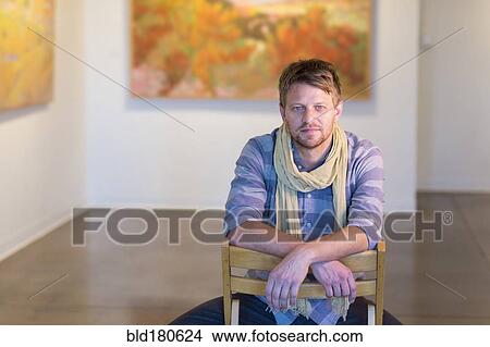 Caucasian man sitting in art gallery View Large Photo Image Picture - Caucasian man sitting in art gallery. Fotosearch