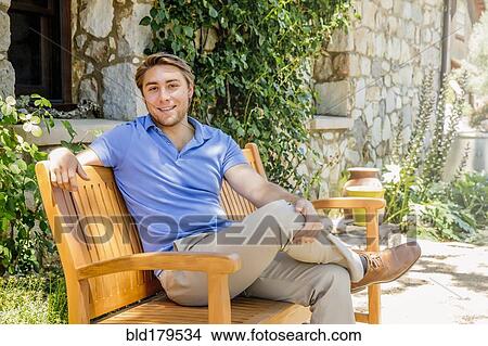 Picture - Caucasian man sitting on bench. Fotosearch