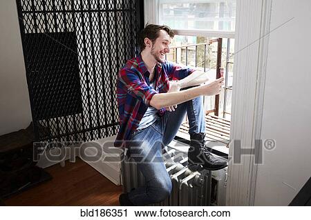 Caucasian man using cell phone in window View Large Photo Image Stock Image - Caucasian man using cell phone in window. Fotosearch