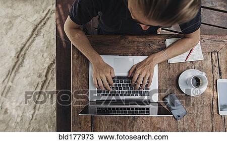Stock Image - Caucasian man using laptop in cafe. Fotosearch