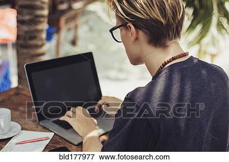 Stock Photo - Caucasian man using laptop outdoors. Fotosearch
