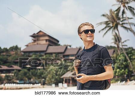 Stock Photograph - Caucasian man walking on beach. Fotosearch