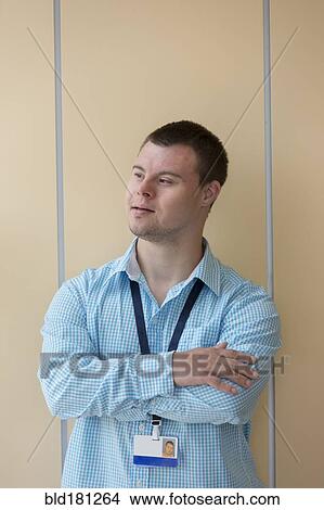 Caucasian man with Down Syndrome wearing badge at wall View Large Photo Image Picture - Caucasian man with Down Syndrome wearing badge at wall. Fotosearch