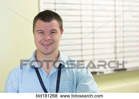 Stock Photo - Caucasian man with Down Syndrome smiling in office. Fotosearch