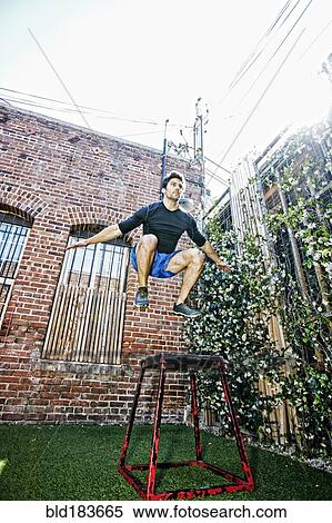 Stock Photography - Caucasian man working out in outdoor gymnasium. Fotosearch