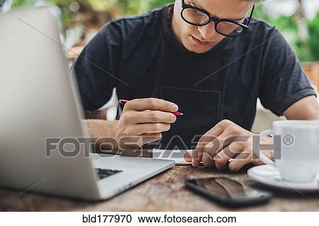 Caucasian man writing in cafe View Large Photo Image Stock Image - Caucasian man writing in cafe. Fotosearch
