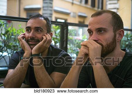 Stock Image - Caucasian men sitting in cafe. Fotosearch