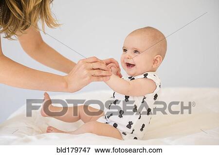 Caucasian mother and baby daughter on bed View Large Photo Image Stock Photo - Caucasian mother and baby daughter on bed. Fotosearch