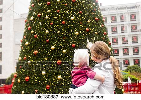 Caucasian mother and daughter admiring Christmas tree View Large Photo Image Stock Photo - Caucasian mother and daughter admiring Christmas tree. Fotosearch