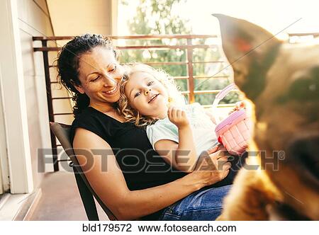 Caucasian mother and daughter playing with dog on patio View Large Photo Image Stock Image - Caucasian mother and daughter playing with dog on patio. Fotosearch