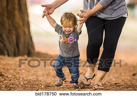 Stock Image - Caucasian mother and daughter walking outdoors. Fotosearch