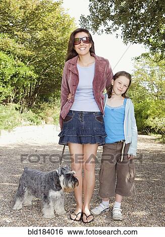Caucasian mother and daughter walking dog on path View Large Photo Image Stock Photograph - Caucasian mother and daughter walking dog on path. Fotosearch