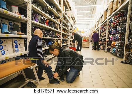Stock Image - Caucasian mother and son shopping in store. Fotosearch