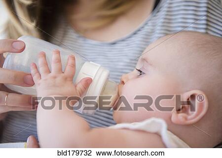 Caucasian mother feeding baby daughter View Large Photo Image Stock Image - Caucasian mother feeding baby daughter. Fotosearch