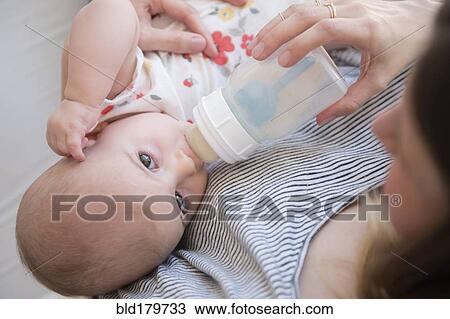 Caucasian mother feeding baby daughter View Large Photo Image Stock Image - Caucasian mother feeding baby daughter. Fotosearch