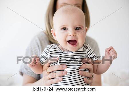Picture - Caucasian mother holding baby daughter. Fotosearch