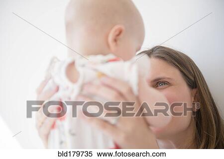 Caucasian mother holding baby daughter View Large Photo Image Stock Photography - Caucasian mother holding baby daughter. Fotosearch