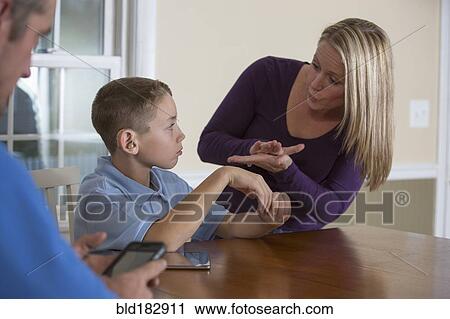 Stock Image - Caucasian mother signing with deaf son. Fotosearch