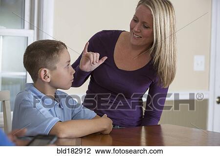 Stock Image - Caucasian mother signing with deaf son. Fotosearch