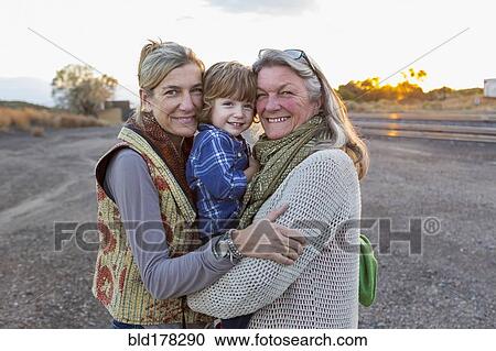 Stock Image - Caucasian mother, son and grandmother smiling outdoors. Fotosearch