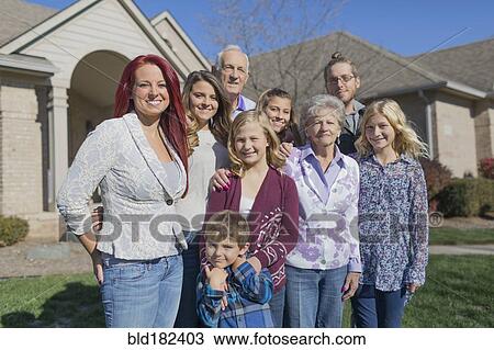 Stock Image - Caucasian multi-generation family smiling in yard. Fotosearch