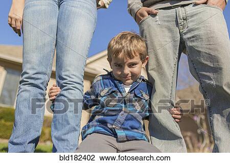 Stock Image - Caucasian parents and son smiling outdoors. Fotosearch