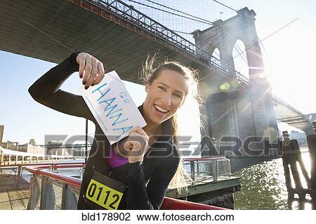 "Caucasian runner holding race sign, New York, New York, United States" View Large Photo Image Stock Image - "Caucasian runner holding race sign, New York, New York, United States". Fotosearch