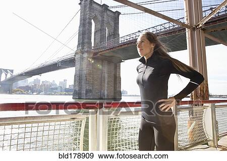 Stock Photo - "Caucasian runner standing on waterfront, New York, New York, United States". Fotosearch