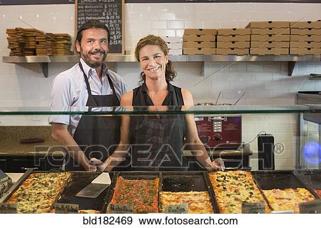 Stock Photo - Caucasian servers smiling in cafe. Fotosearch