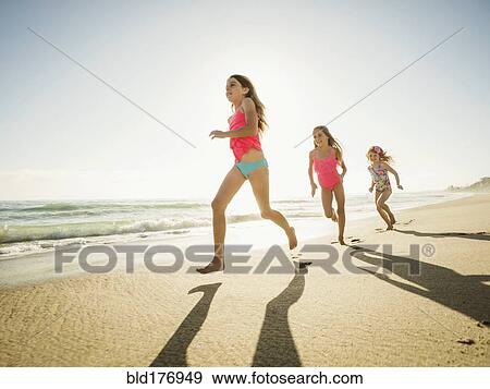 Caucasian sisters running on beach View Large Photo Image Stock Photo - Caucasian sisters running on beach. Fotosearch