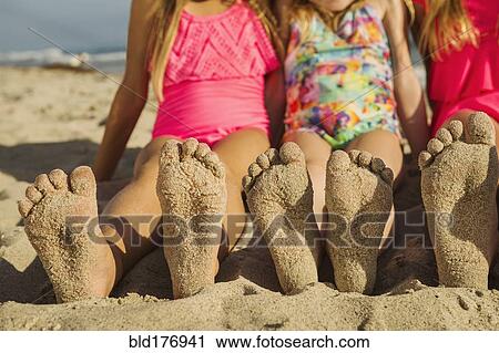 Caucasian sisters with sandy feet on beach View Large Photo Image Stock Image - Caucasian sisters with sandy feet on beach. Fotosearch